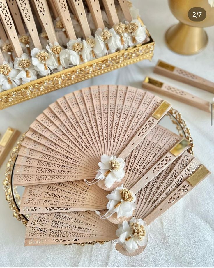 an elaborately decorated wooden fan sits on a table next to other decorative items and accessories