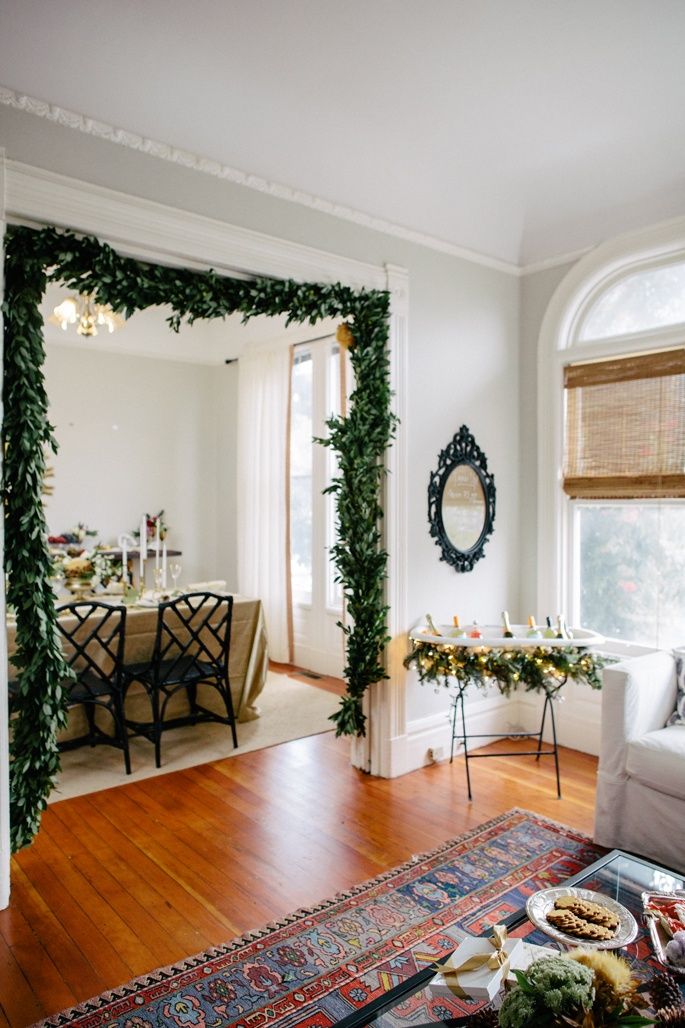 a living room filled with furniture next to a window covered in plants and greenery