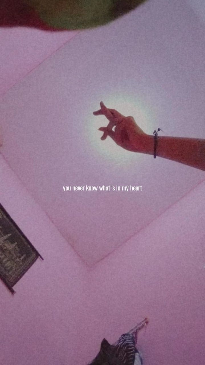 a hand reaching up towards the ceiling in a room that has pink walls and carpet