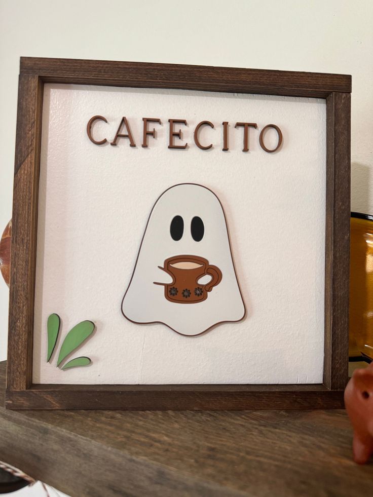 a sign that says cafecito with a ghost holding a coffee cup in front of it