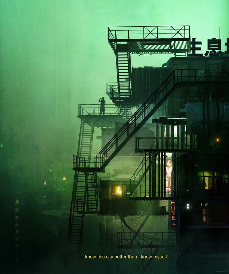 an industrial building with fire escape stairs in the foreground and foggy sky behind it