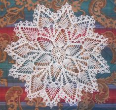 a crocheted doily on a colorful background