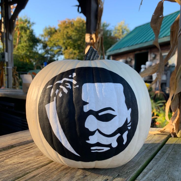 a black and white pumpkin sitting on top of a wooden table