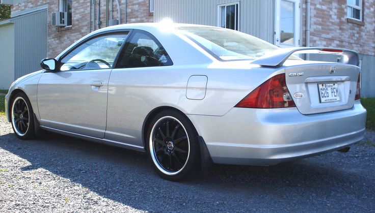 a silver car parked in front of a brick building