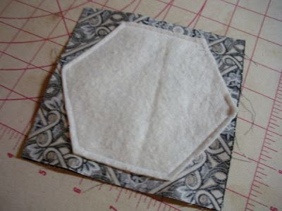 two pieces of fabric sitting on top of a piece of cloth next to a ruler