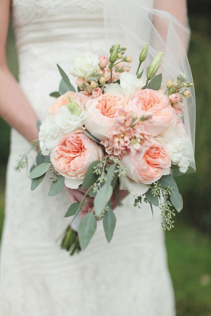 a bridal holding a bouquet of pink and white flowers