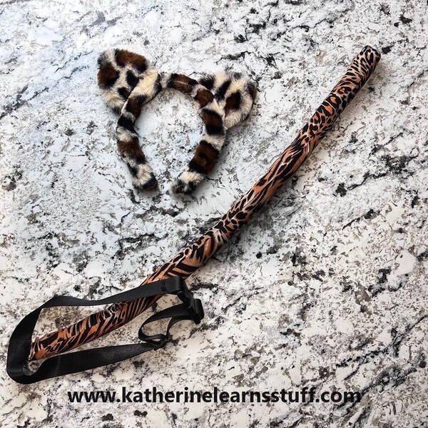 an animal print umbrella laying on top of a marble floor next to a pair of scissors