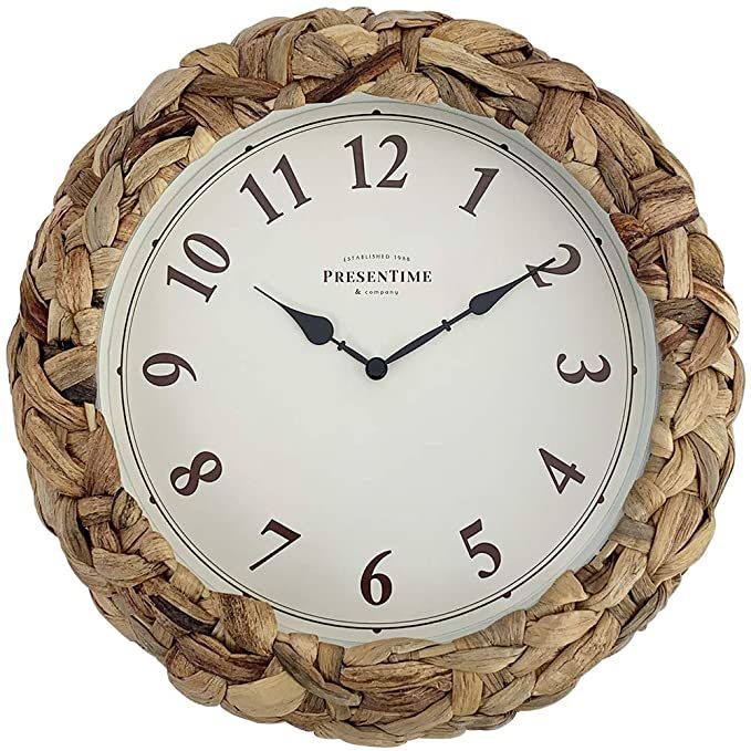 a white clock with black numbers on it's face is in a woven basket