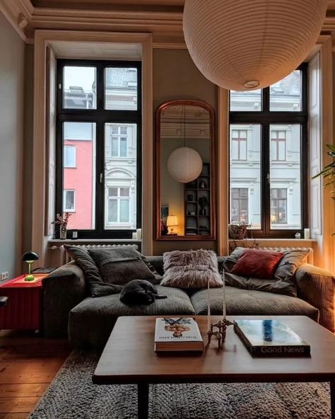 a living room filled with furniture and large windows