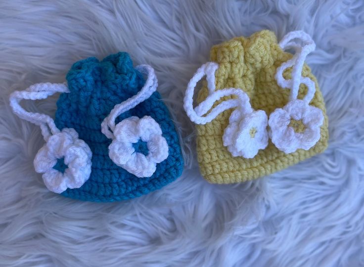 two crocheted purses sitting on top of a white furnishing floor