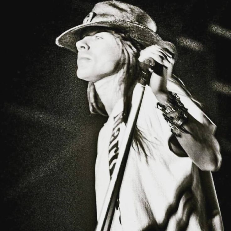 a black and white photo of a person with a hat on holding a baseball bat