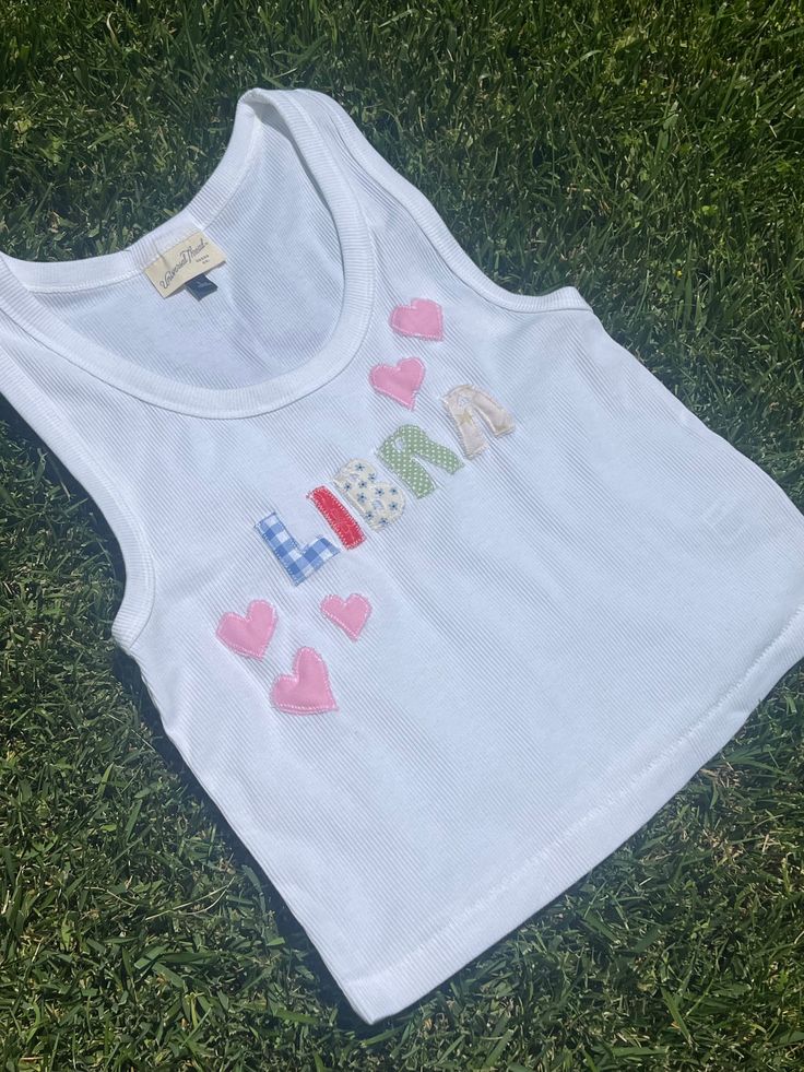 a white shirt with hearts on it sitting in the grass