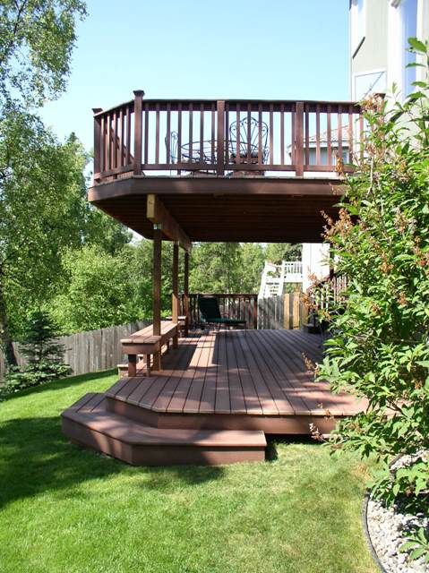 a wooden deck in the middle of a yard