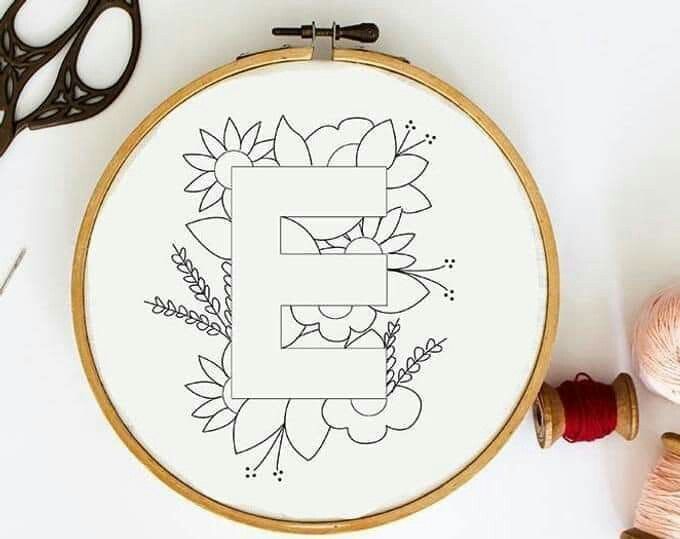 the letter e is surrounded by flowers and leaves in this embroidery pattern, along with some scissors