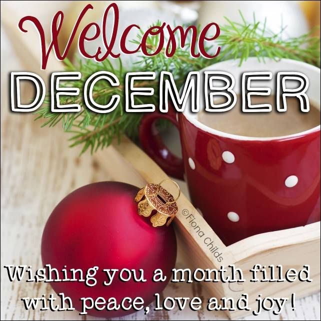 a coffee cup and christmas ornament sitting on top of a wooden table with the words, welcome december