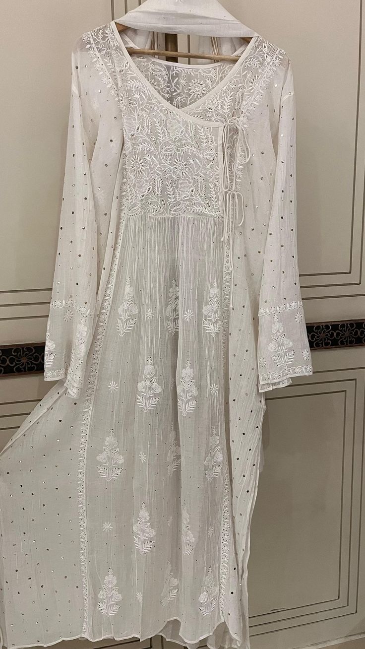 Discover the epitome of timeless elegance with our Pure Cotton Silk Angarkha Set, adorned with vintage Chikankari Ek Taar embroidery. This exquisite piece is further embellished with intricate Mukaish and Pitta work, creating a luxurious blend of tradition and modernity. The kurta comes with a matching dupatta and lining, and you have the option to choose between churidhaar or pants for the bottoms, allowing you to tailor the set to your personal style. Each set is customizable to any size, ensuring a perfect fit for everyone. Please send your size specifications before placing your order. Embrace the allure of heritage craftsmanship with this stunning ensemble, perfect for any special occasion. Elegant Chanderi Sherwani For Receptions, Long Raw Silk Dupatta With Intricate Embroidery, Traditional Sherwani With Intricate Embroidery In Georgette, Traditional Georgette Sherwani With Intricate Embroidery, Elegant Chanderi Sherwani With Resham Embroidery, Elegant Georgette Sherwani For Eid, Elegant Intricate Embroidered Fabric For Festive Season, Elegant Embroidered Fabric For Festive Occasions, Semi-stitched Chikankari Kurta For Reception