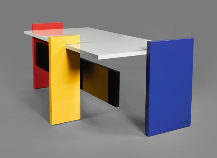 three different colored tables sitting next to each other on a gray surface with grey background