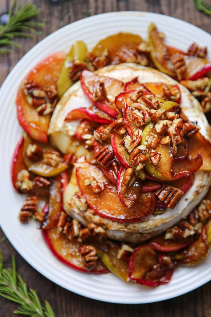 a white plate topped with apples and pecans