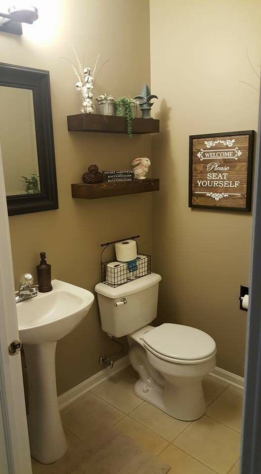 a bathroom with a toilet, sink and shelves on the wall in it's corner