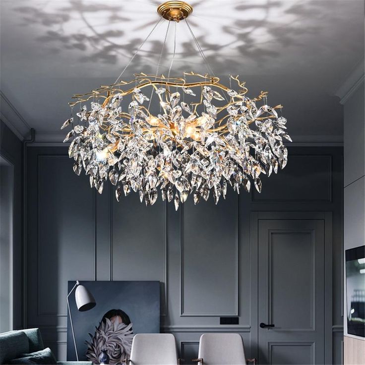 a chandelier hanging from the ceiling in a room with grey walls and furniture