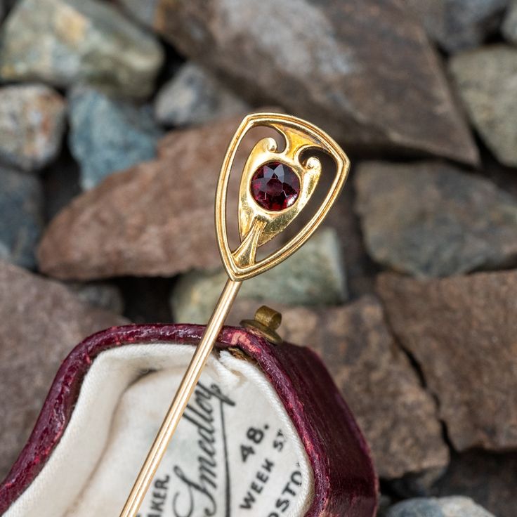 This lovely antique stick pin is crafted of 14k yellow gold and features a round 4mm garnet. Formal Ruby Brooch Jewelry, Antique Style 14k Gold Brooches For Formal Occasions, Antique Style 14k Gold Brooch For Formal Occasions, Hallmarked 14k Gold Brooch For Formal Occasions, Classic 14k Gold Brooches As Gift, Classic 14k Gold Brooches For Gift, Formal Hallmarked 14k Gold Brooches, Elegant Brass Brooch For Gift, Elegant Brass Brooches For Collectors