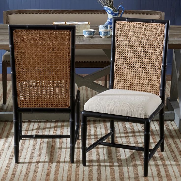 two chairs sitting next to each other in front of a table