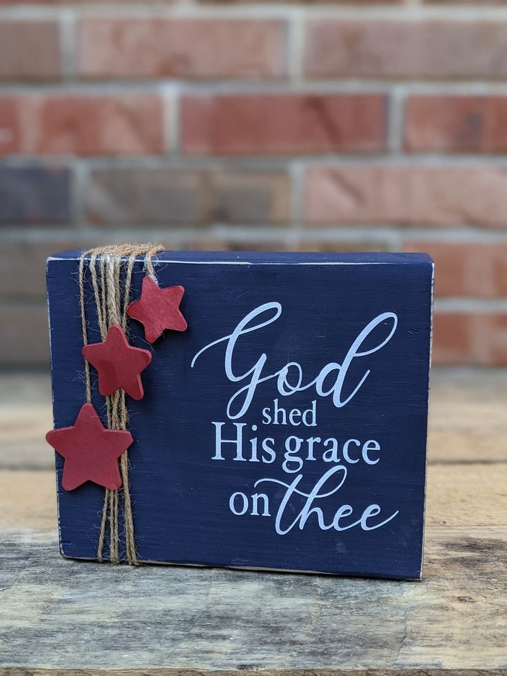 a blue box with red stars tied to it that says god shed his grace on thee