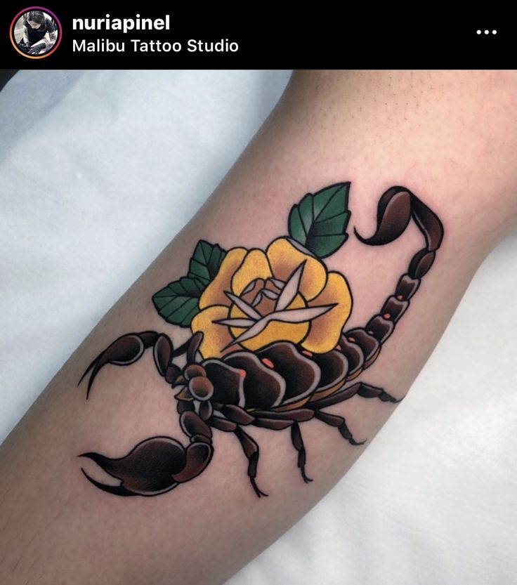 a scorpion with a yellow rose tattoo on its arm