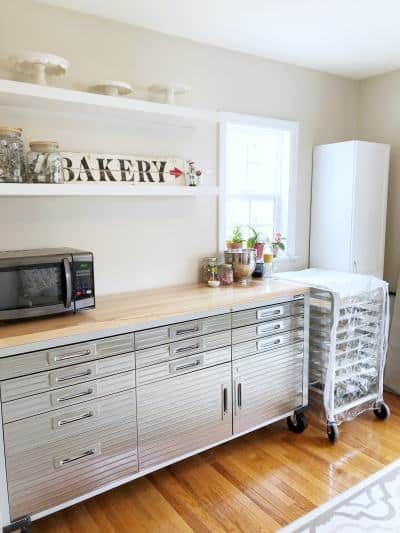 an empty kitchen with stainless steel cabinets and white appliances on the counter top, next to a window