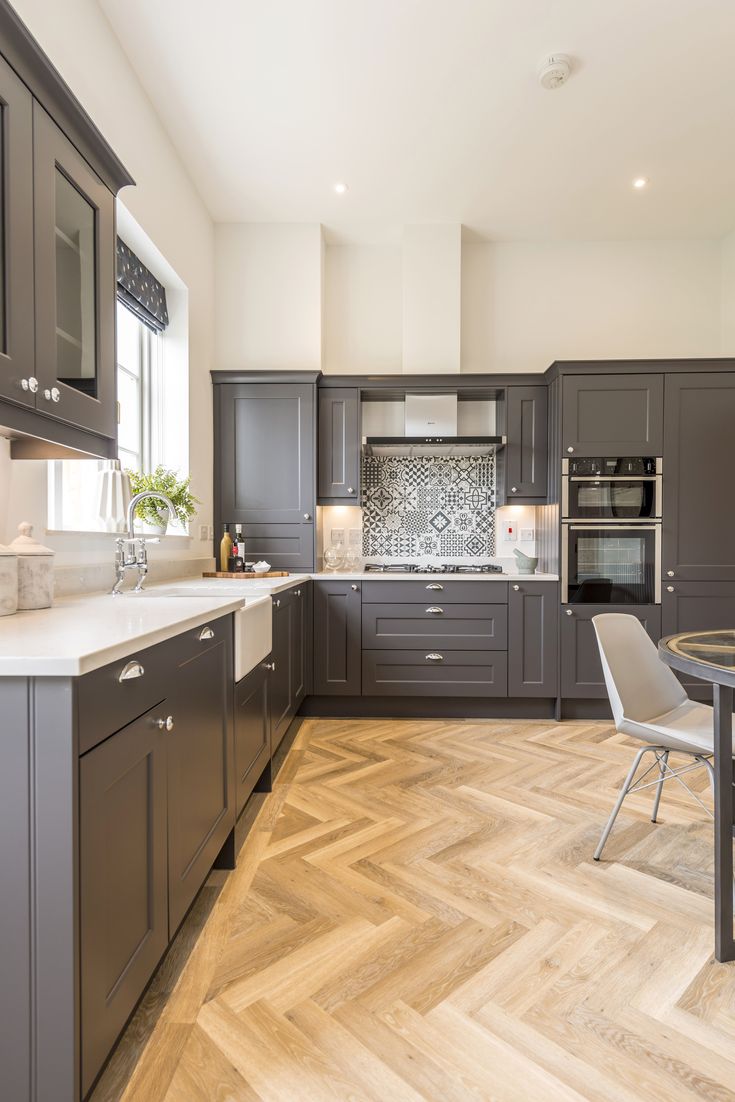 a modern kitchen with wood flooring and gray cabinets