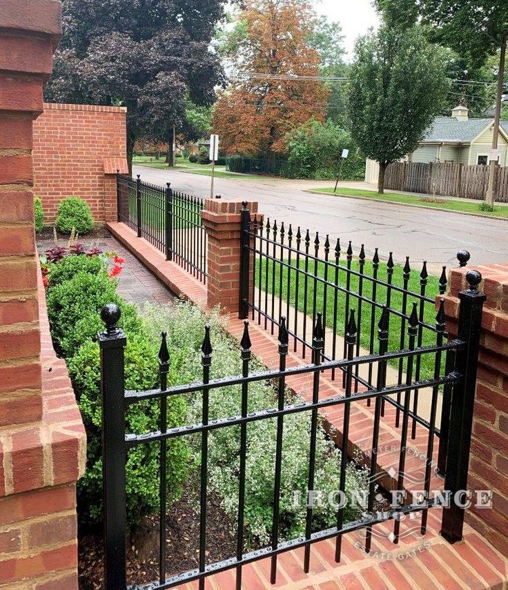 a black iron fence next to a brick building