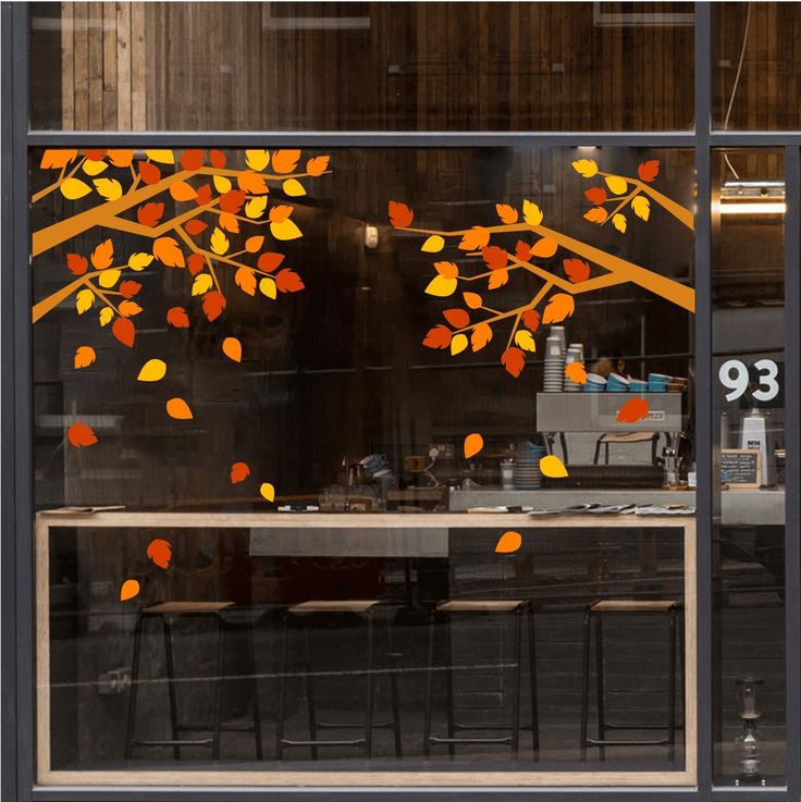 the window is decorated with an orange tree and yellow leaves on it's branches