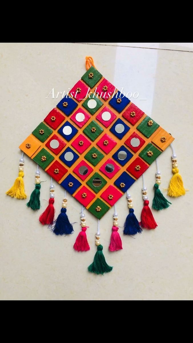 a multicolored square with tassels hanging from it