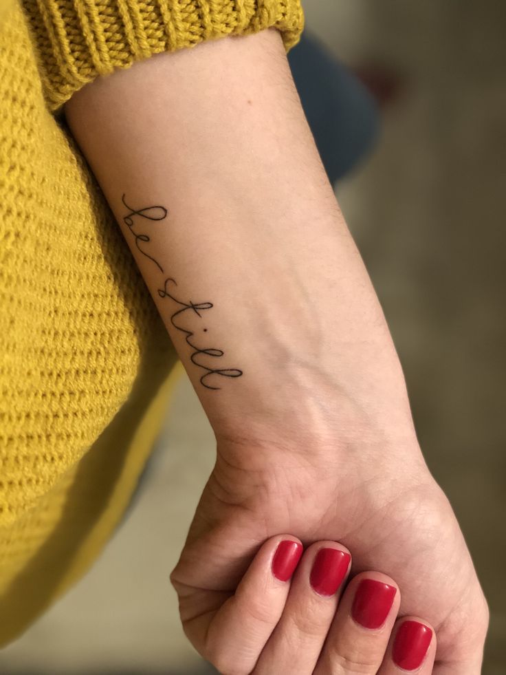 a woman's hand with a small tattoo on her wrist that reads, love and faith