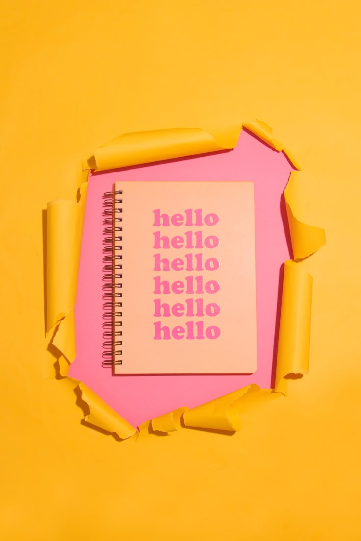 an open notebook with the words hello hello written on it and torn up pieces of paper