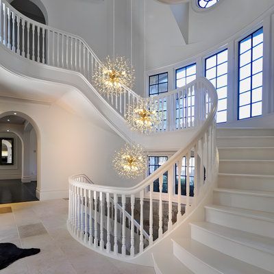 a large white staircase with chandeliers and windows