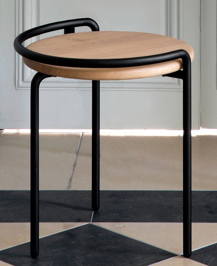 a wooden table sitting on top of a black and white checkered floor next to a door