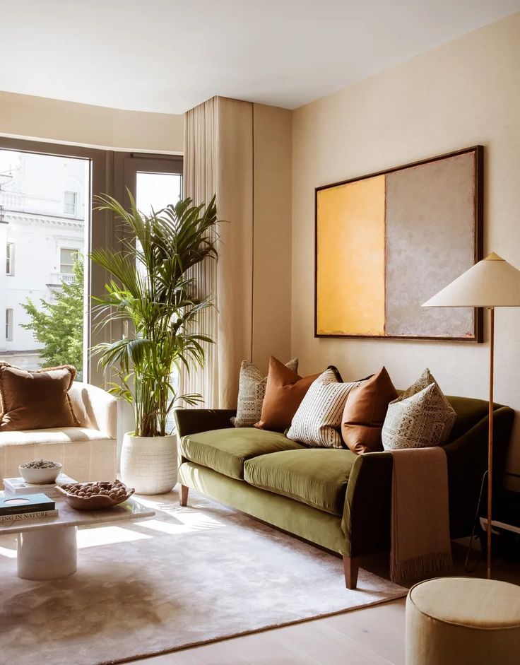 a living room filled with furniture and a plant in the corner on top of a coffee table