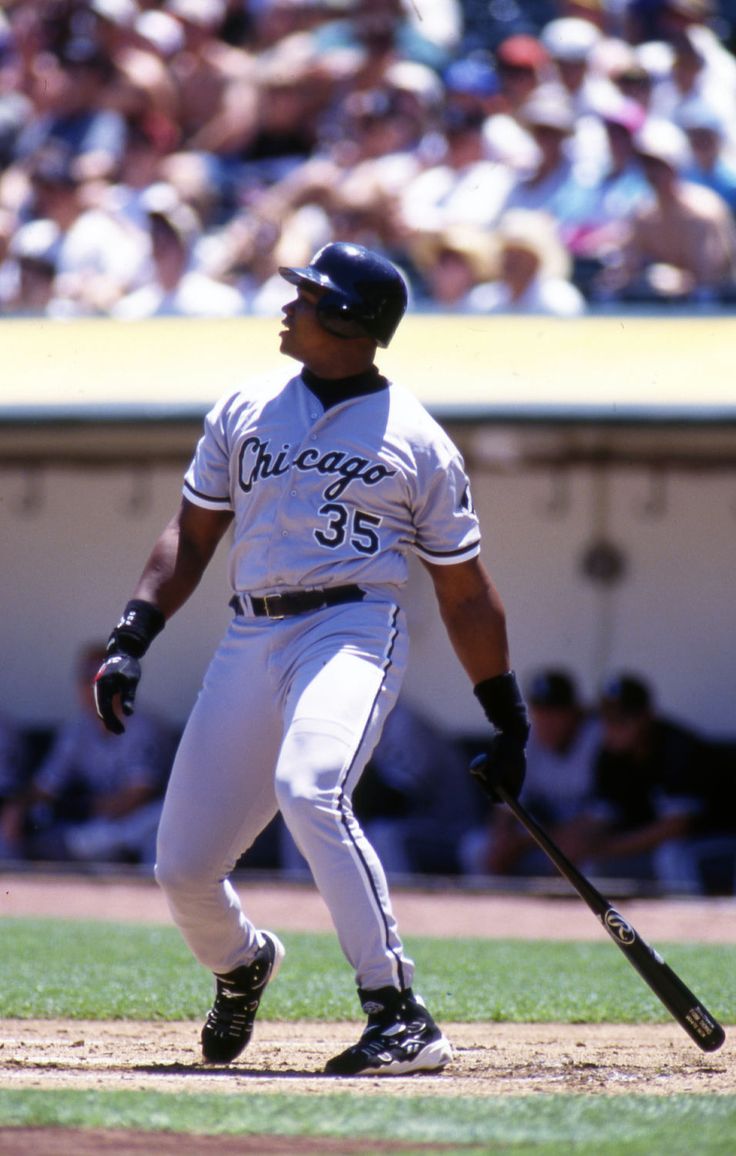 a baseball player holding a bat on top of a field in front of a crowd