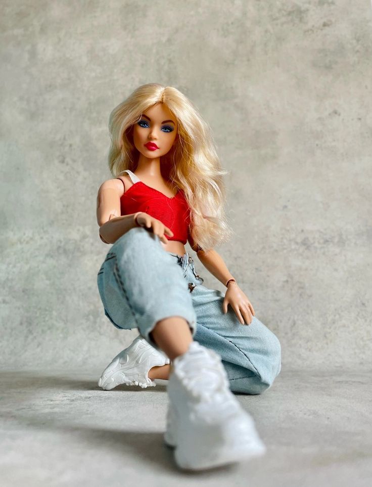 a barbie doll sitting on the ground with her legs spread out and shoes in front of her