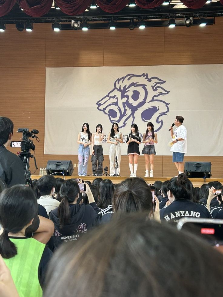 a group of people standing on top of a stage with microphones in front of them