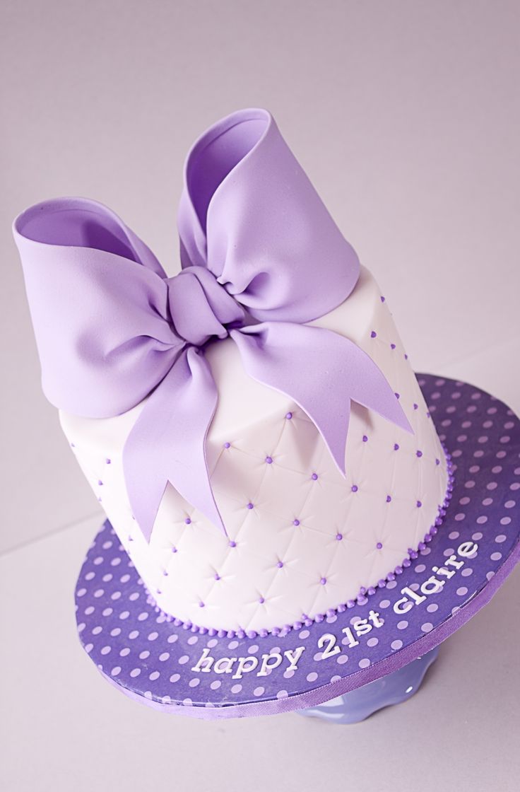 a purple and white cake with a big bow on top