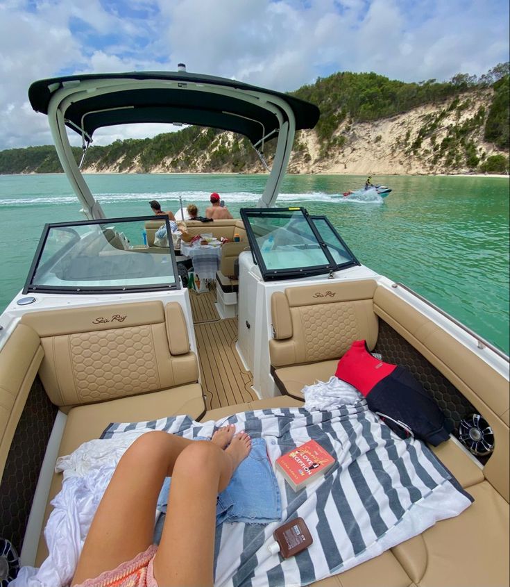 a woman laying on top of a boat in the water