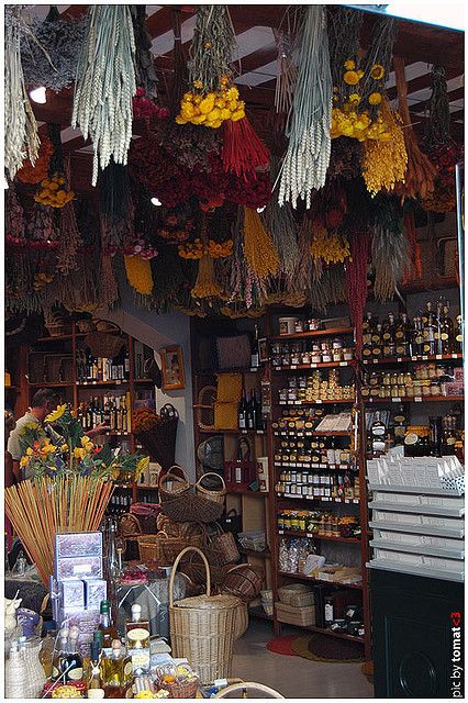 an open market with lots of fruits and vegetables hanging from the ceiling