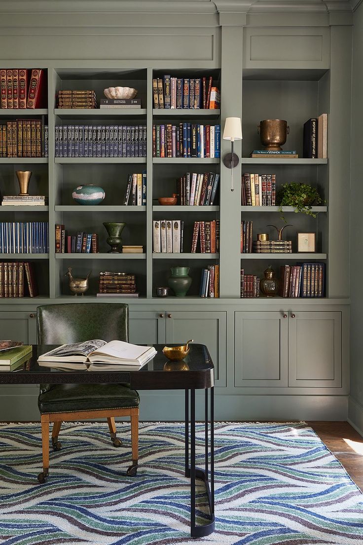 a living room with bookshelves and a table in front of the bookcases