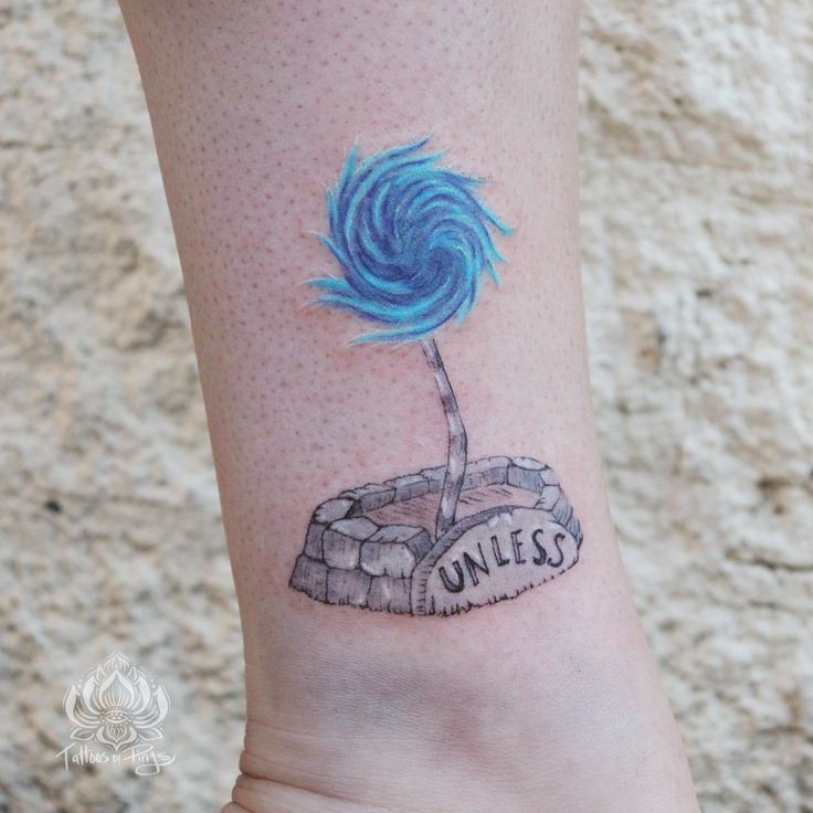 a small blue lollipopo on the ankle with words written below it that says unless