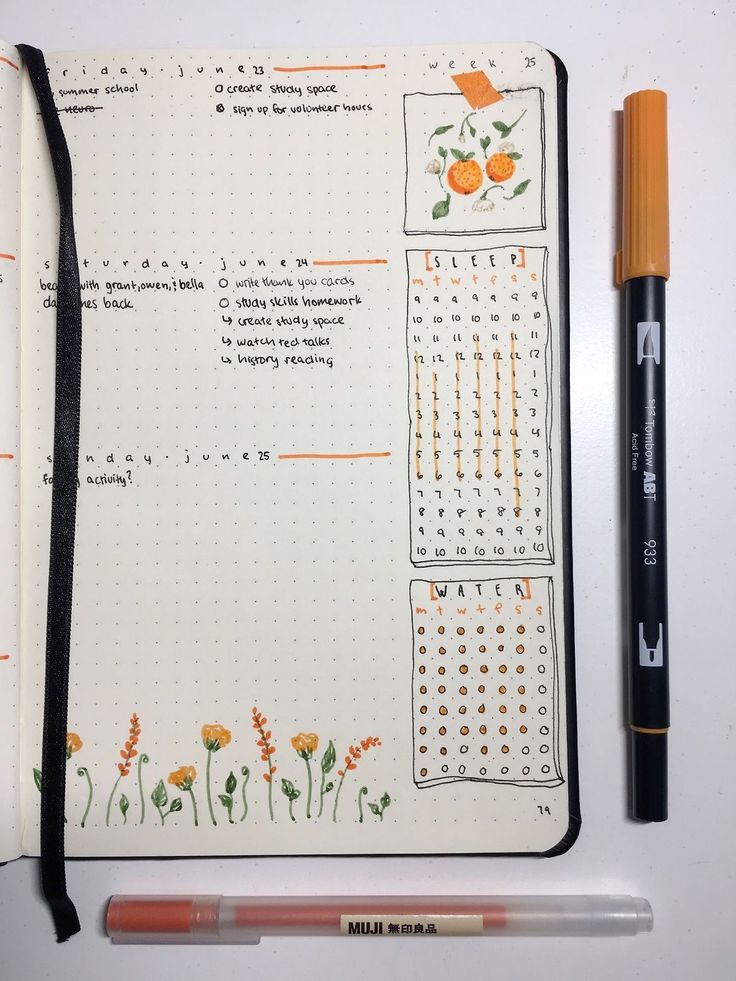 an open notebook with flowers on it next to a marker and pen in the middle