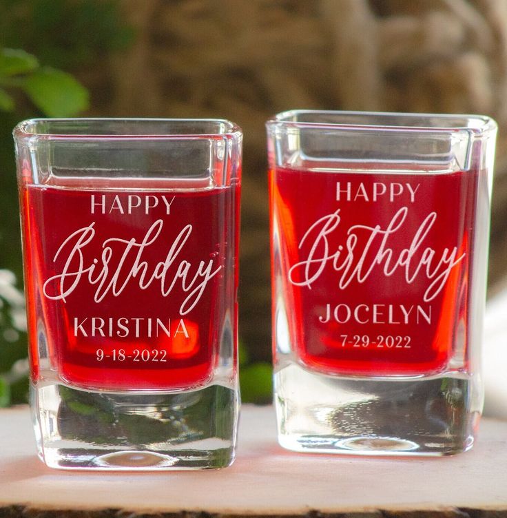 two personalized shot glasses sitting on top of a table