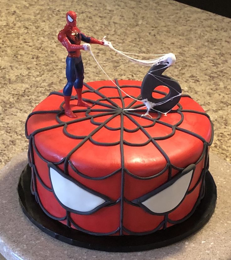 a spider - man cake is decorated with fondant and sprinkled icing