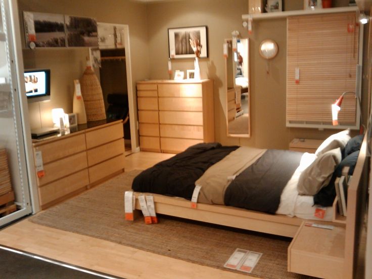 a bed room with a neatly made bed and dressers